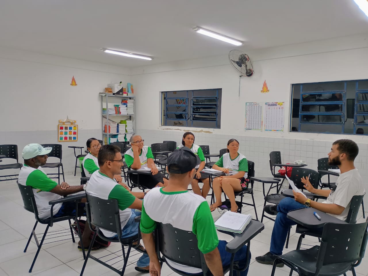 Alunos da EJA sentados em roda junto com professor.